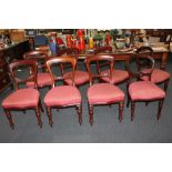 A set of six Victorian mahogany balloon back dining chairs, with red upholstered seats, on turned