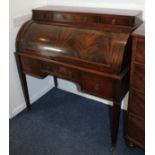 A late 19th / early 20th century mahogany cylinder desk, the top with surmount of three small self