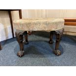 An oval upholstered stool, on carved cabriole legs to claw and ball feet (a/f)