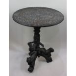 A highly ornate Indian carved circular occasional table with floral decorated top on baluster stem