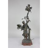 After Moreau, a bronzed metal figural table lamp in the form of a figure posing amongst flowers,