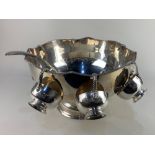 A large silver on copper punch bowl, with scalloped rim and lion mask ring handles, together with