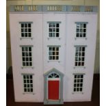 A Regency style three floor doll's house, with hinged pink and white facade enclosing six rooms,