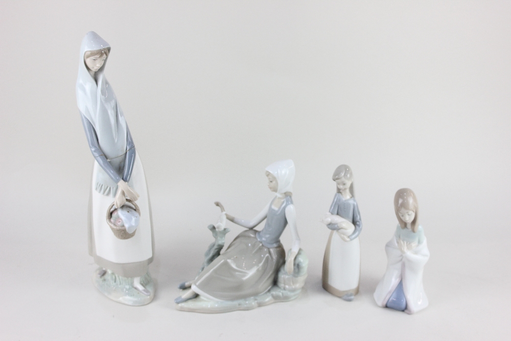 Two Lladro porcelain figures of ladies, one seated beside a dove, 17cm high, the other holding a