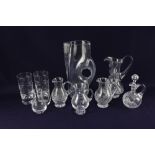 A collection of glass jugs, to include one in the shape of a leather jug, together with two