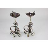A pair of W A S Benson style copper and brass candlesticks, with scrolling stems on tripod bases,