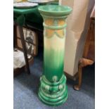 An Art Nouveau Bermantofts faience jardiniere stand, in green and yellow glaze, marks to