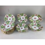 A 19th century porcelain part dessert service, decorated with floral sprays, within green and gilt