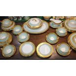An Aynsley porcelain part dinner service, with a pale green band and gilt borders, comprising oval
