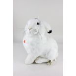 A Steiff white plush toy of Hoppel the snow hare, seated, with maker's tags and ear button, 40cm