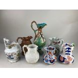 A collection of seven 19th century pottery jugs, including a majolica example with overlaid floral