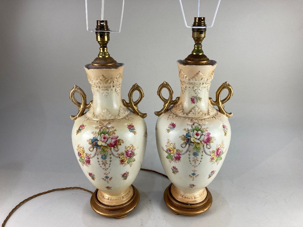 A pair of Victorian baluster vases now as table lamps, decorated with floral sprays on cream