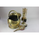 A brass coal scuttle, a set of four brass fire tools, and a small pair of bellows decorated with a
