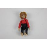 A Schuco monkey label pin / brooch, dressed in red felt top and black trousers, 9cm high