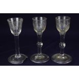 A pair of 18th century wine glasses, the ogee bowls with floral engraving, plain stems with centre