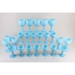 A collection of pale blue milk glass drinking glasses, comprising ten large goblets, eleven small