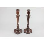 A pair of wooden candlesticks, each with tapered baluster stems on hexagonal base, 32cm high