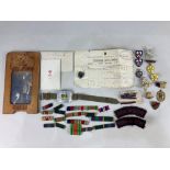 A collection of World War I and II militaria, including medal ribbons, a TA badge with receipt,