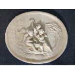A large oval wall plaque embossed with cherubs playing musical instruments, the cream painted raised