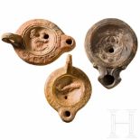 Three Roman oil lamps, 1st - 2nd centuryLamp without handle, on the central disc a laurel wreath.