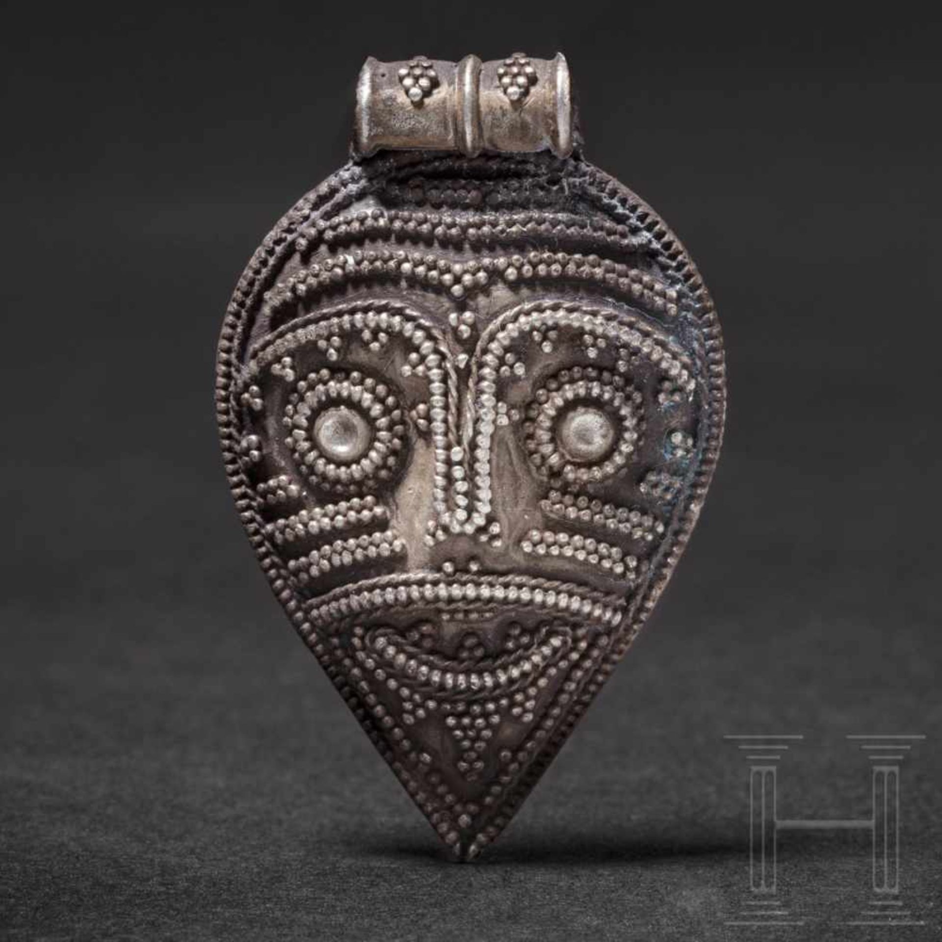 A Viking silver pendant with warrior head, 10th – 11th centuryA silver pendant representing the face