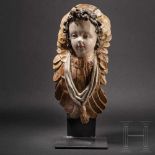A delicately carved and ploychromely painted South German head of an angel from the workshop of