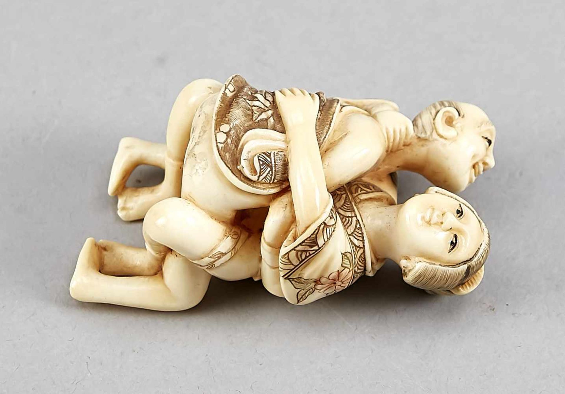 A Japanese shunga figure around 1900, ivory carved in the round, incised decor in colours,