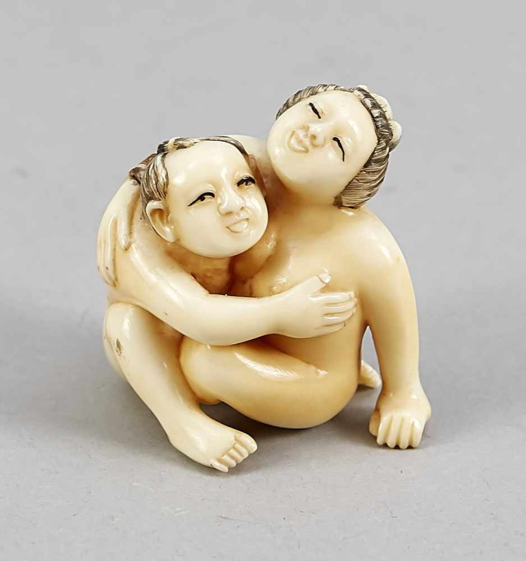 A Japanese shunga figure around 1900, ivory carved in the round, incised decor in colours,