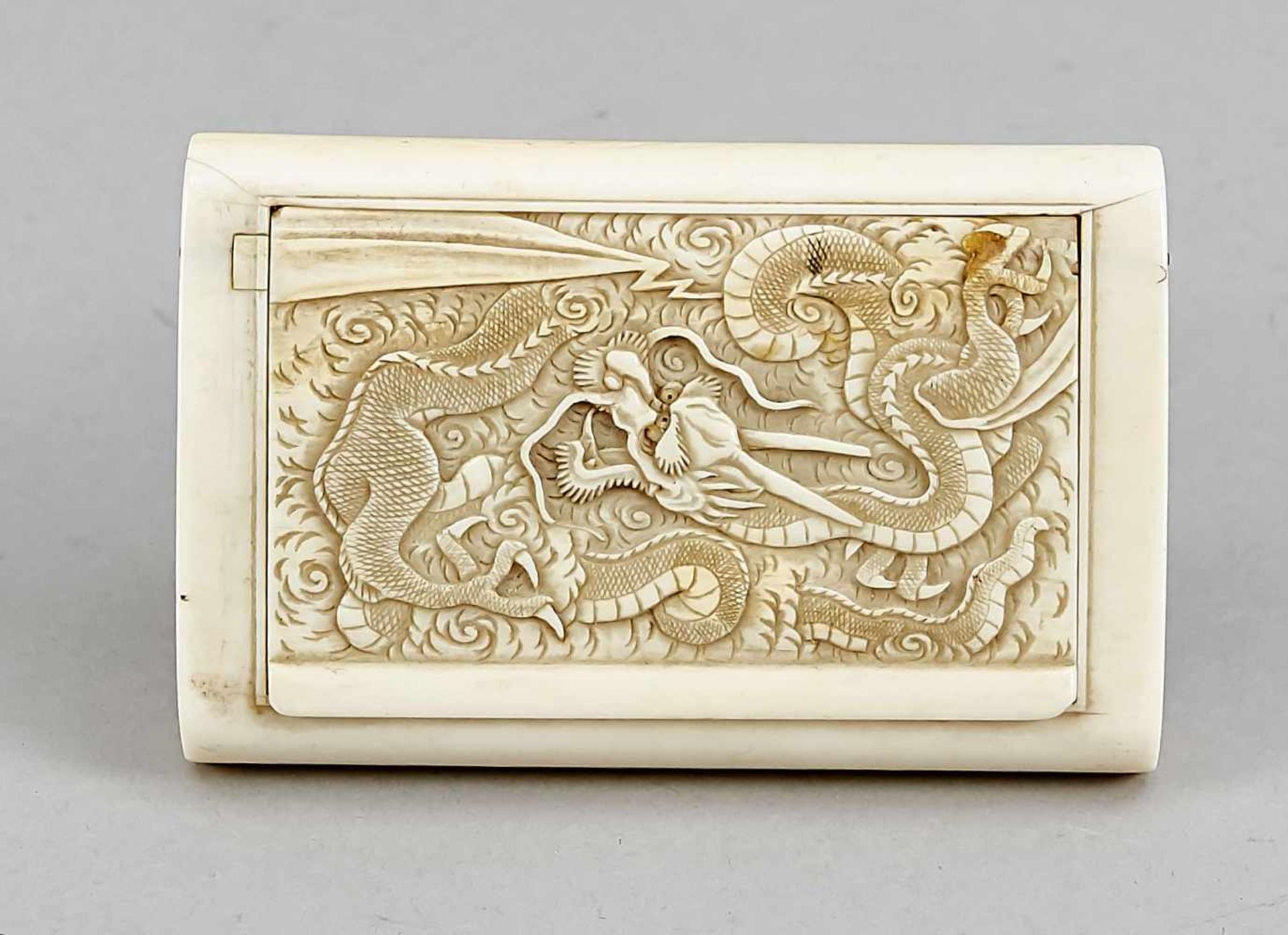 A Japanese ivory cigarette box around 1900 of rectangular shape, the hinged cover carved