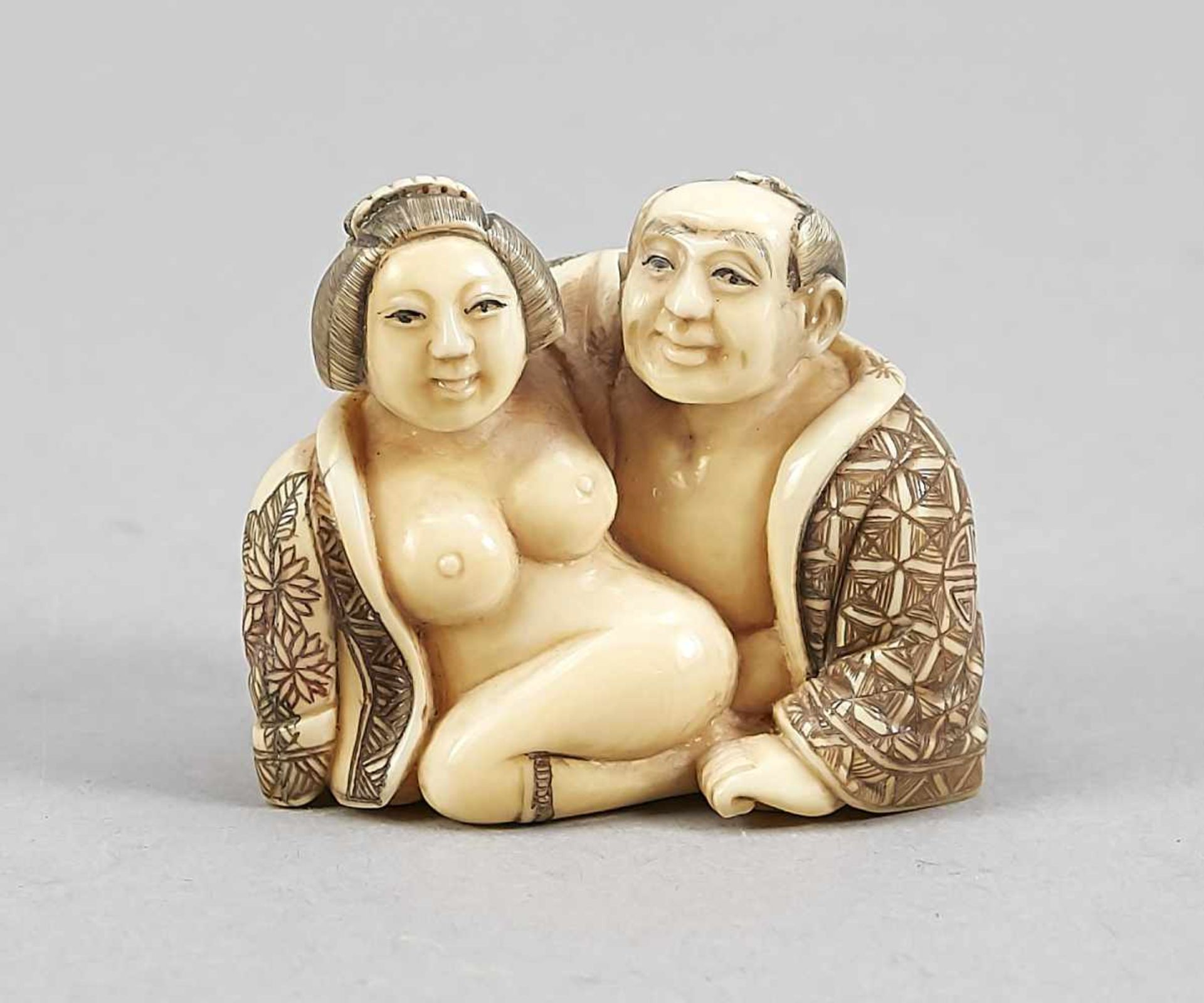 A Japanese shunga figure around 1900, ivory carved in the round, incised decor in colours,