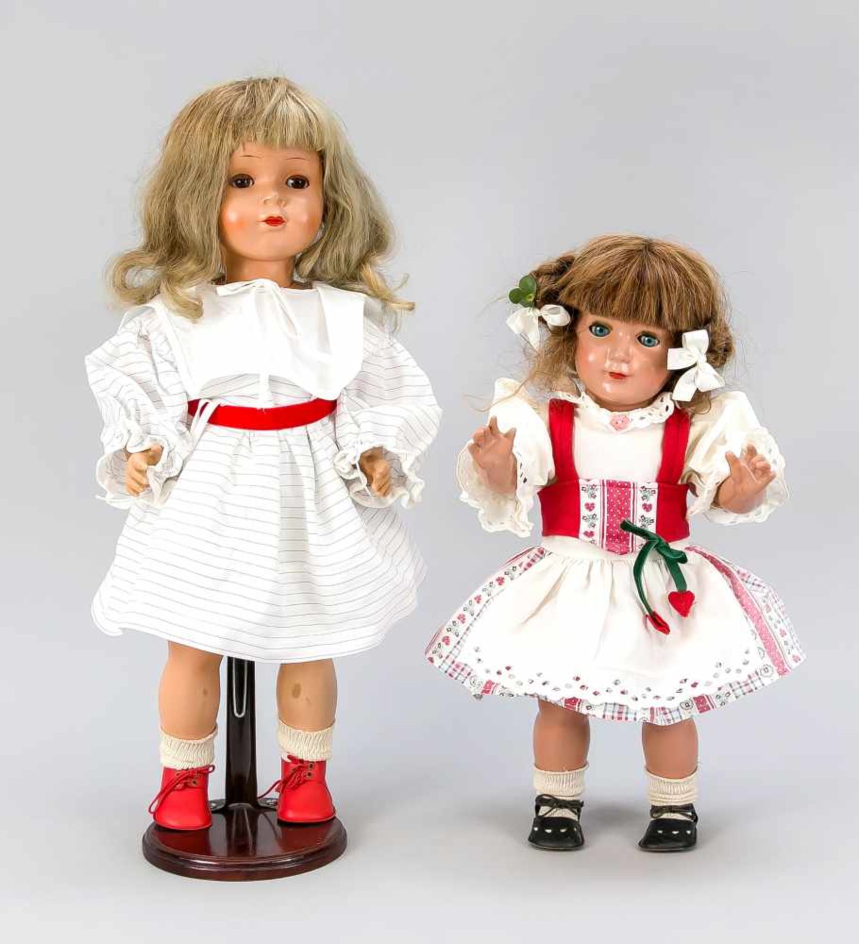 2 Kunststoffpuppen, 1. H. 20. Jh. Mädchen in adretten Kleidchen, 1 x blond mit Display (H.