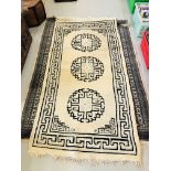 A PERSIAN STYLE CARPET WITH BLACK DESIGN ON CREAM GROUND - APPROX 72 INCH X 49 INCH AND ONE OTHER