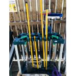 A GARDEN IMPLEMENT STAND CONTAINING HOE'S, RAKES, BULLDOG BORDER FORK & SPADE,