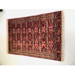 AN EASTERN RED / BLUE PATTERNED CARPET - APPROX 60 INCH X 41 INCH