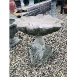 A STONEWORK GARDEN BIRD BATH SUPPORTED BY THREE FISH,