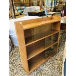 A SOLID LIGHT OAK BOOKCASE WITH SLIDING GLASS DOORS