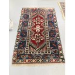 AN EARLY C20TH ORIENTAL RUG WITH CENTRAL CRUCIFORM DESIGN (WORN CONDITION) APPROX 78 INCH X 49 INCH