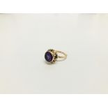 A LADIES ROSE GOLD PURPLE STONE SET RING MARKED 14K