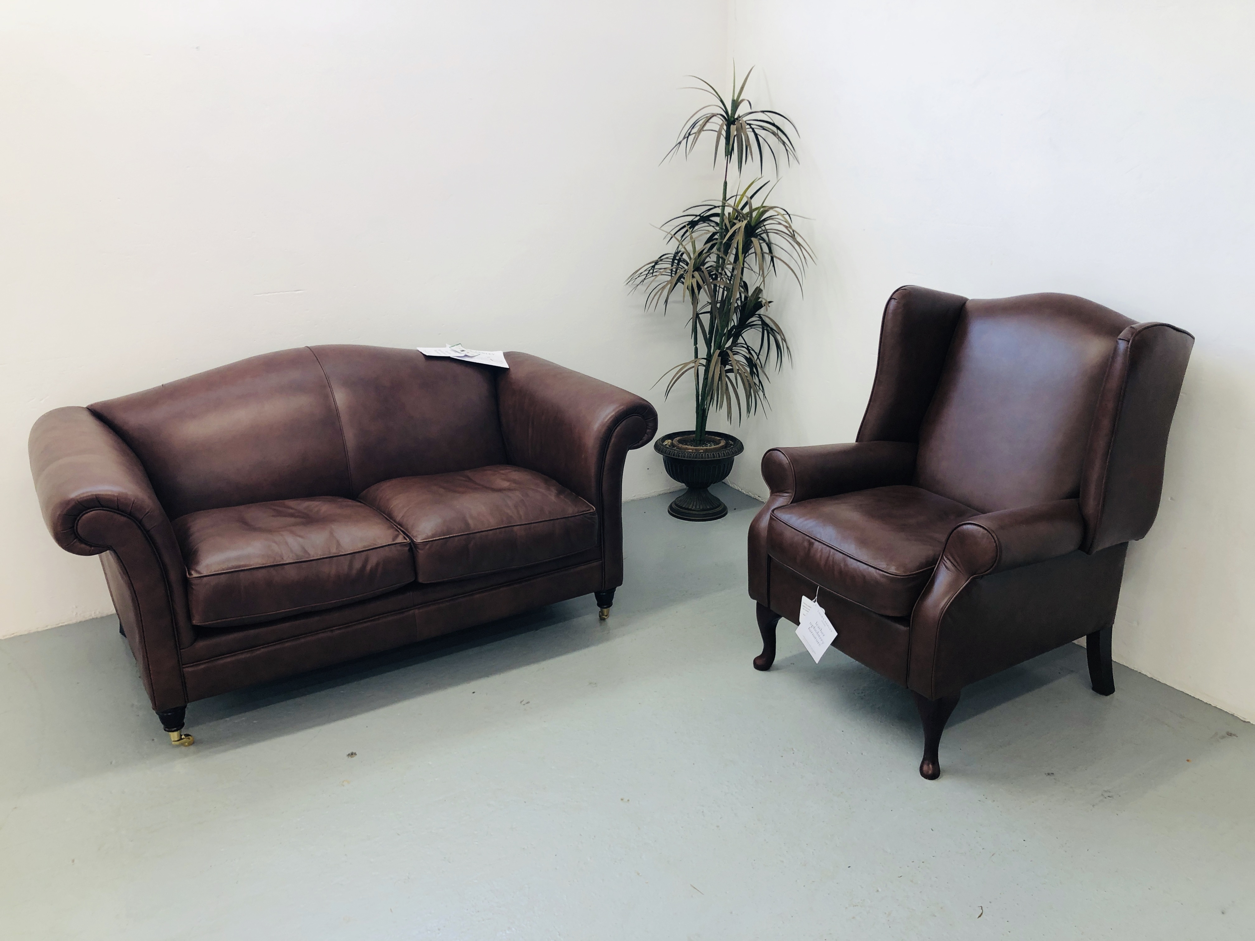 A LAURA ASHLEY TAN LEATHER TWO SEATER SOFA AND MATCHING LAURA ASHLEY TAN LEATHER WINGED RECLINER