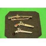 3 VINTAGE DECORATIVE BROOCHES IN THE FORM OF FLINTLOCK PISTOLS AND MUSKET