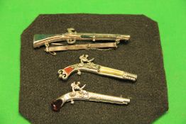 3 VINTAGE DECORATIVE BROOCHES IN THE FORM OF FLINTLOCK PISTOLS AND MUSKET