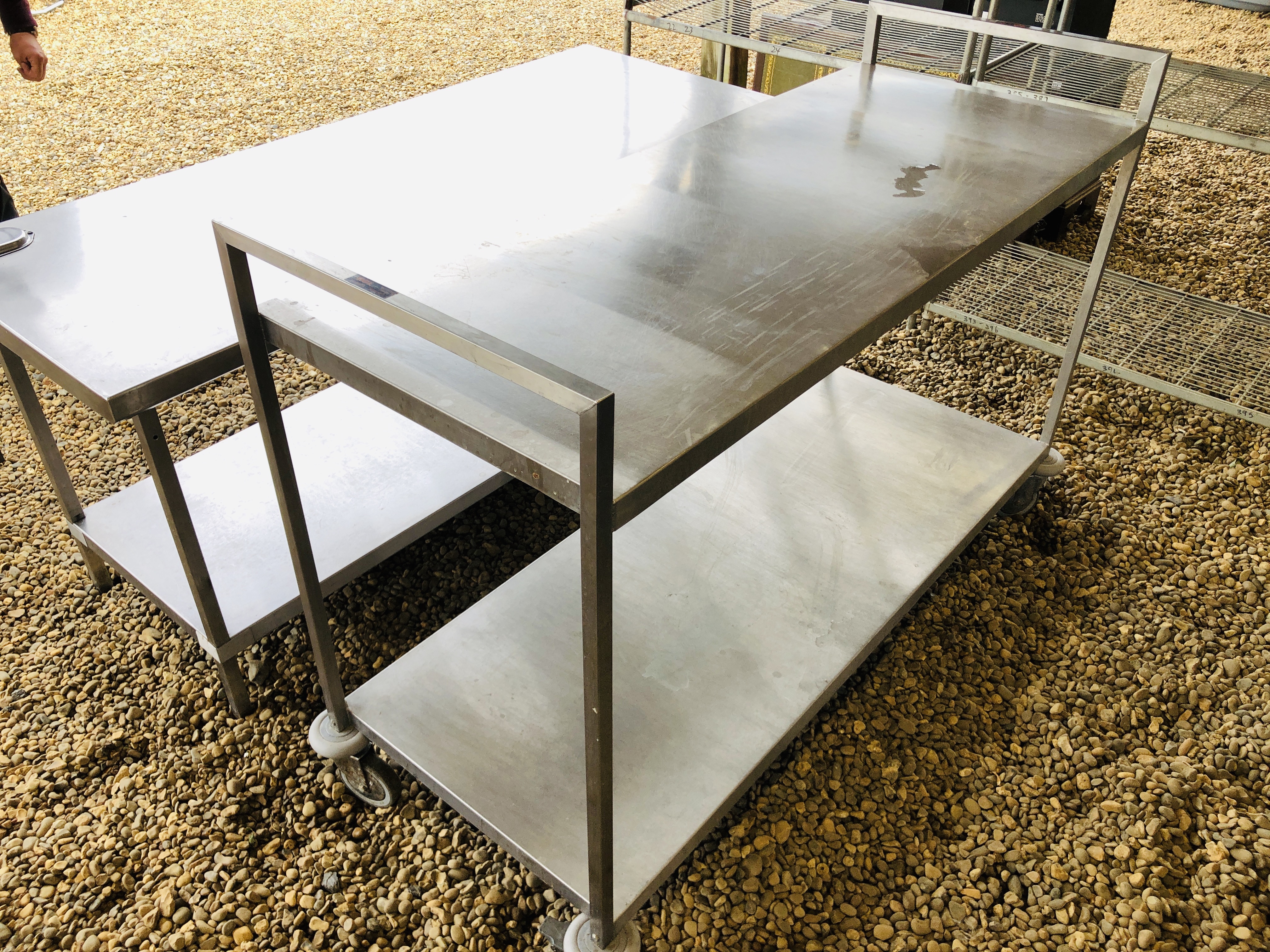 A STAINLESS STEEL COMMERCIAL TWO TIER WHEELED PREPARATION TABLE LENGTH 65 INCH WIDTH 25 INCH