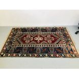 AN EARLY C20TH ORIENTAL RUG WITH CENTRAL CRUCIFORM DESIGN (WORN CONDITION) APPROX 78 INCH X 49 INCH