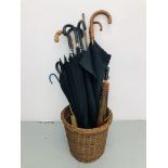 A WICKER BASKET CONTAINING A COLLECTION OF UMBRELLAS TO INCLUDE WHANGEE HANDLED AND TWO ORIENTAL