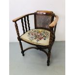 AN OAK BOW CHAIR WITH FLORAL NEEDLE CRAFT UPHOLSTERED SEAT AND RATTAN PANEL TO BACK