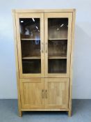 A MODERN BEECHWOOD FULL HEIGHT CABINET THE TOP TWO GLAZED DOORS ABOVE CABINET BASE HEIGHT 75 INCH,