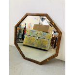 AN OCTAGONAL FRAMED AND BEVELLED GLASS WALL MIRROR,
