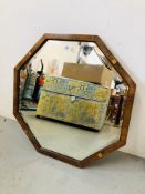 AN OCTAGONAL FRAMED AND BEVELLED GLASS WALL MIRROR,