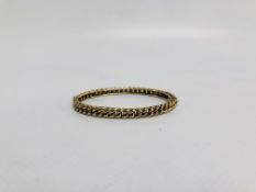 A YELLOW METAL ROPE DESIGN BANGLE MARKED