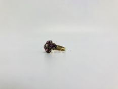 AN AMETHYST FLOWER HEAD RING, CENTRED WI